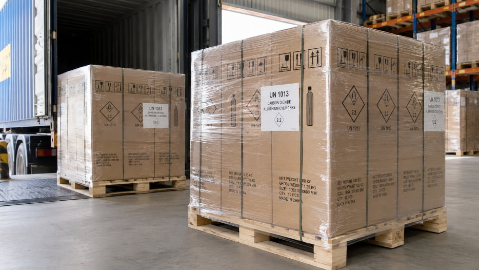 A pallet of CO2 cylinders properly packaged and labeled for international shipping.